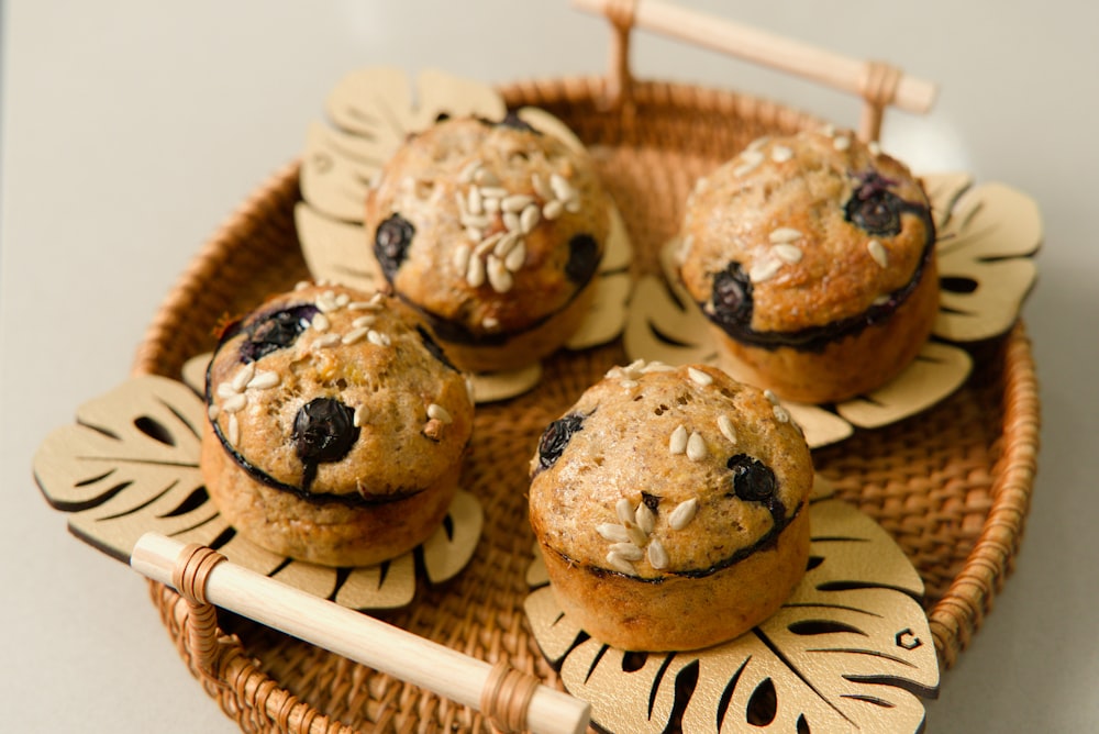 uma cesta de vime cheia de muffins em cima de uma mesa