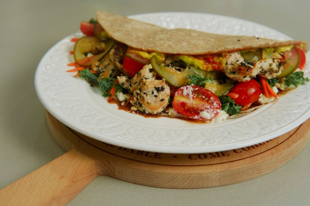 A colorful chicken shawarma wrap sliced in half showing tender meat and herbs