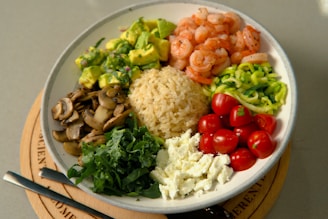 a plate of food with shrimp, rice, and vegetables