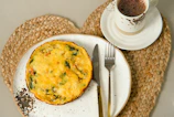 Freshly baked vegetable quiche cooling on a rustic wooden table