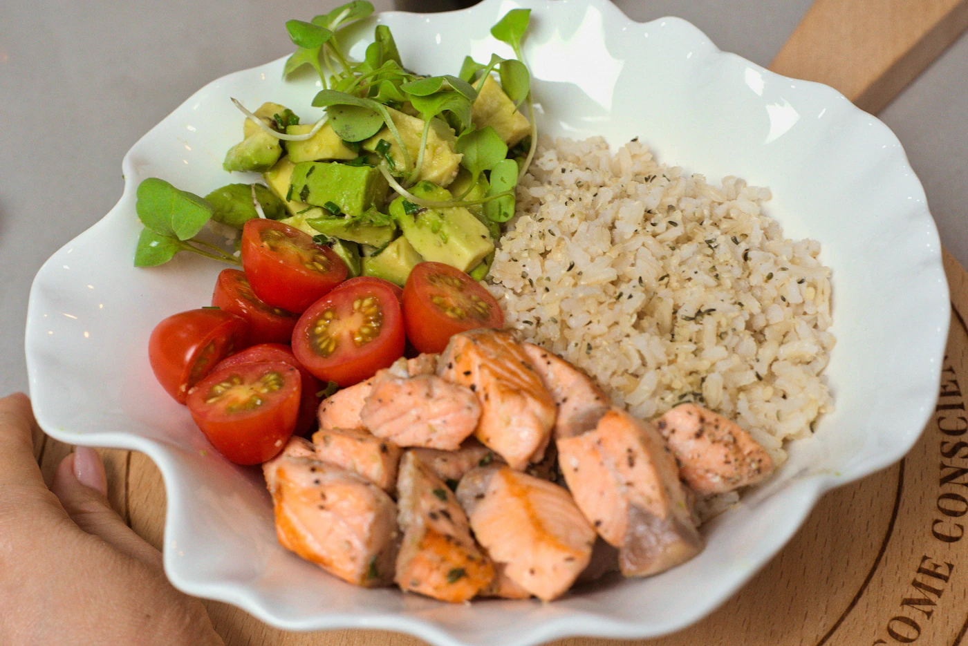Prato branco com salmão, arroz integral, abacate, tomate e folhas verdes — montagem de refeição de baixo índice glicêmico
