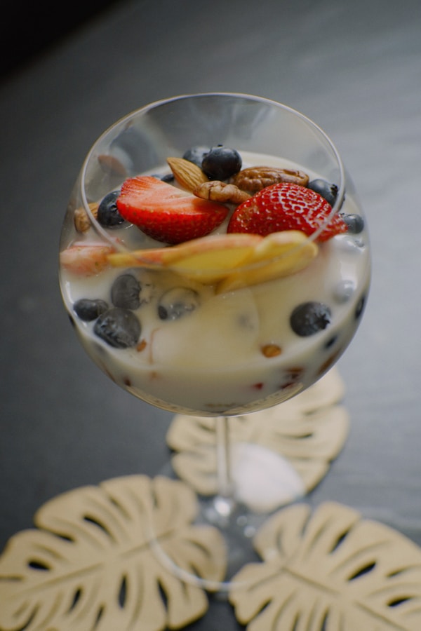 A glass of yogurt with fruit on top