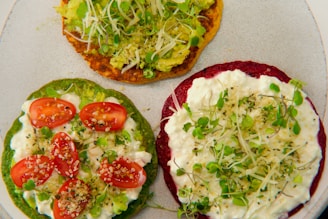 three small pizzas with toppings on a plate