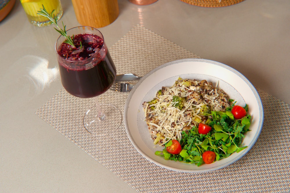 ein Teller mit Essen und ein Glas Wein auf einem Tisch