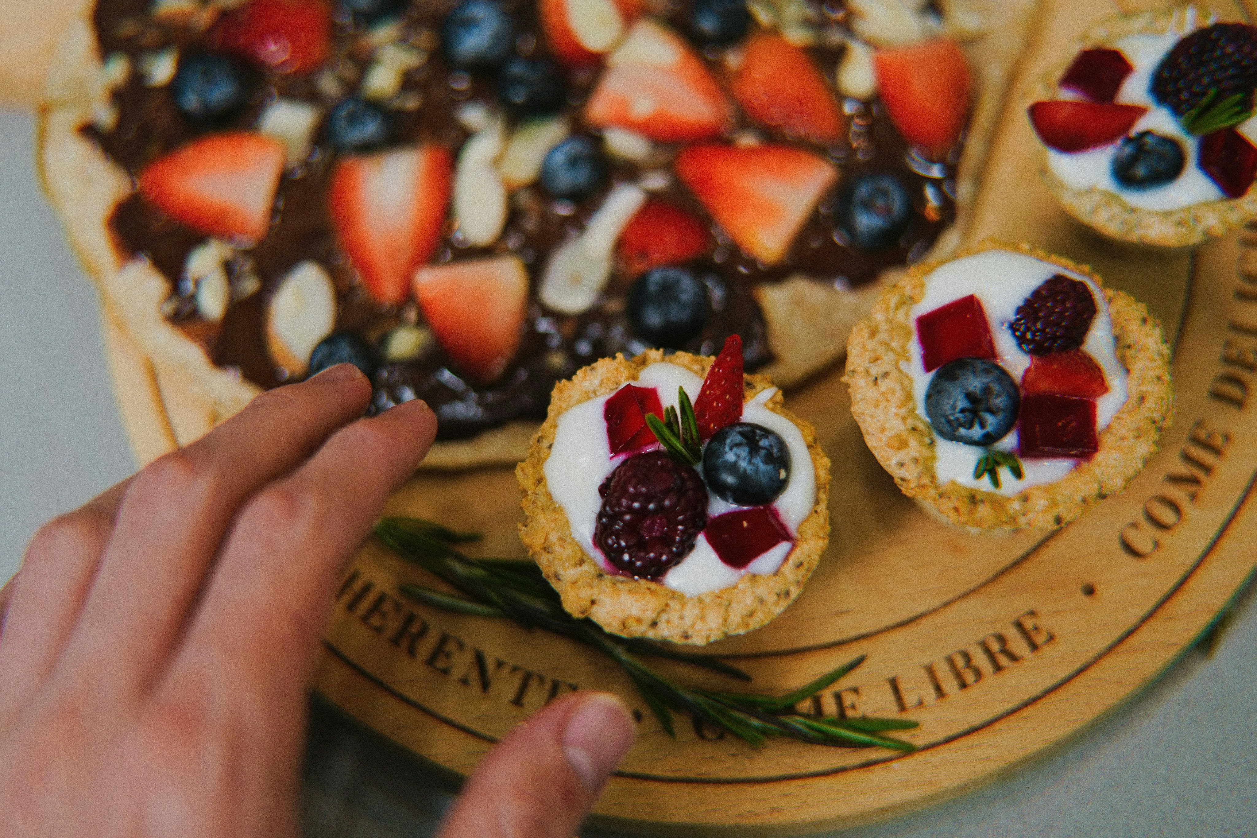 a person reaching for a dessert on a plate