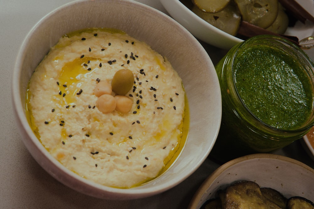 a bowl of hummus and a bowl of pickles