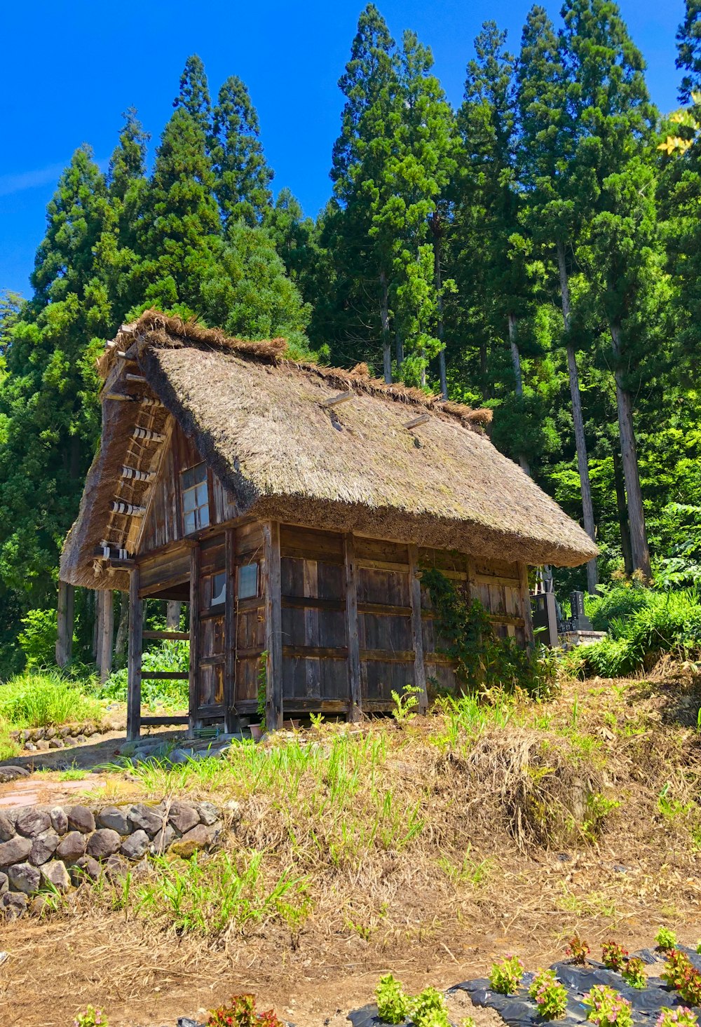 a small wooden house with a thatched roof