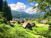 A peaceful rural scene with traditional houses nestled among lush hills.