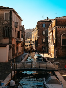 a boat is docked in a canal between two buildings