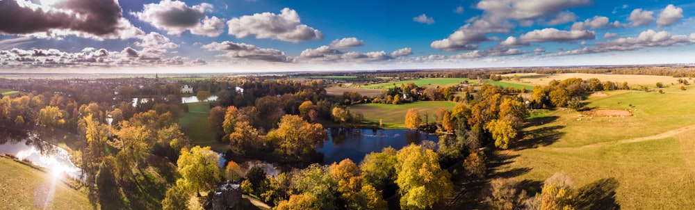 an aerial view of a green field and a lake