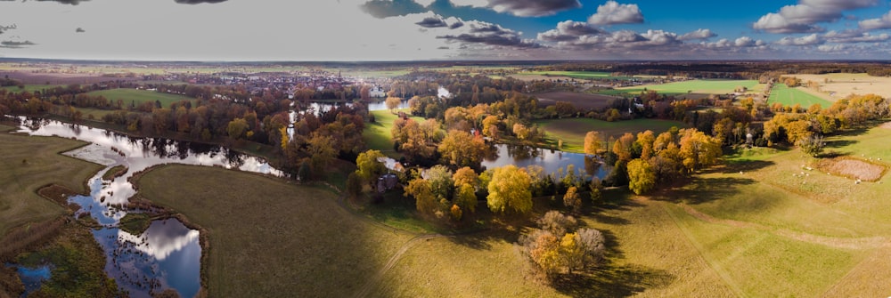 an aerial view of a river running through a lush green field