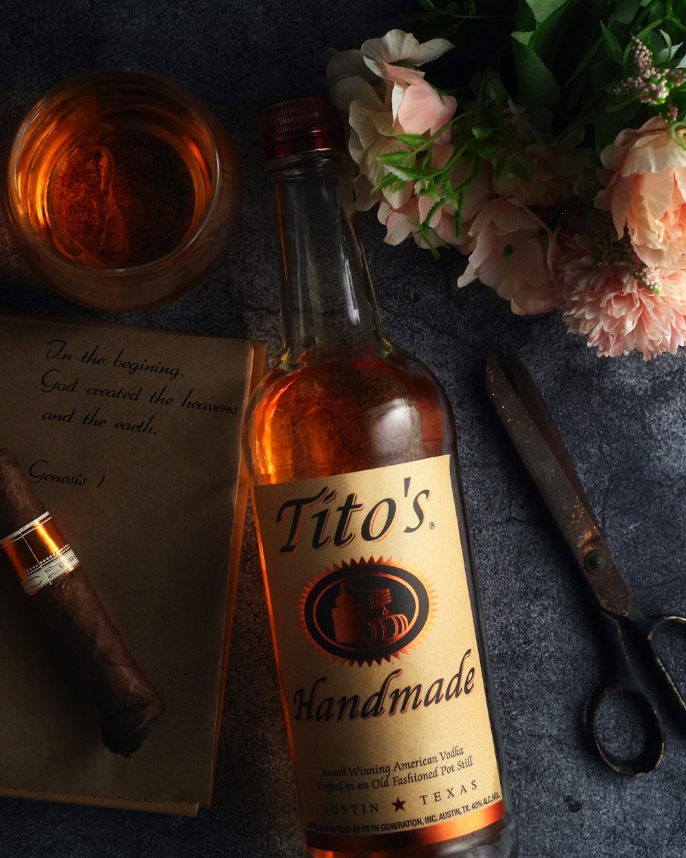 Une bouteille de cigare fait à la main de Tito à côté d’une paire de ciseaux