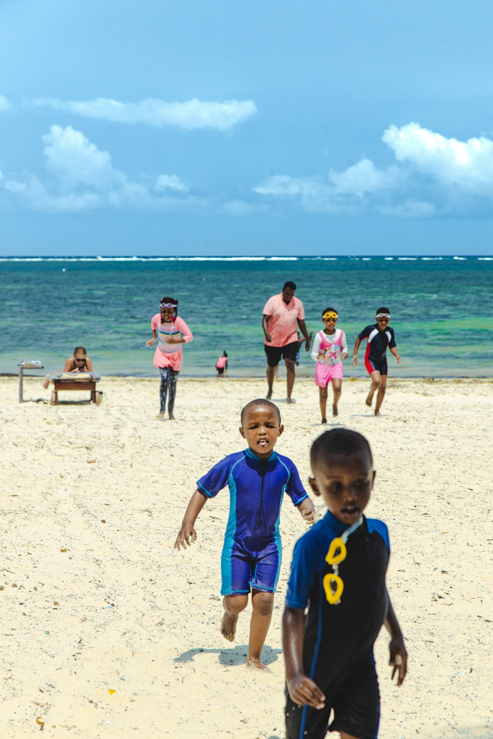 a group of children playing soccer on a beach