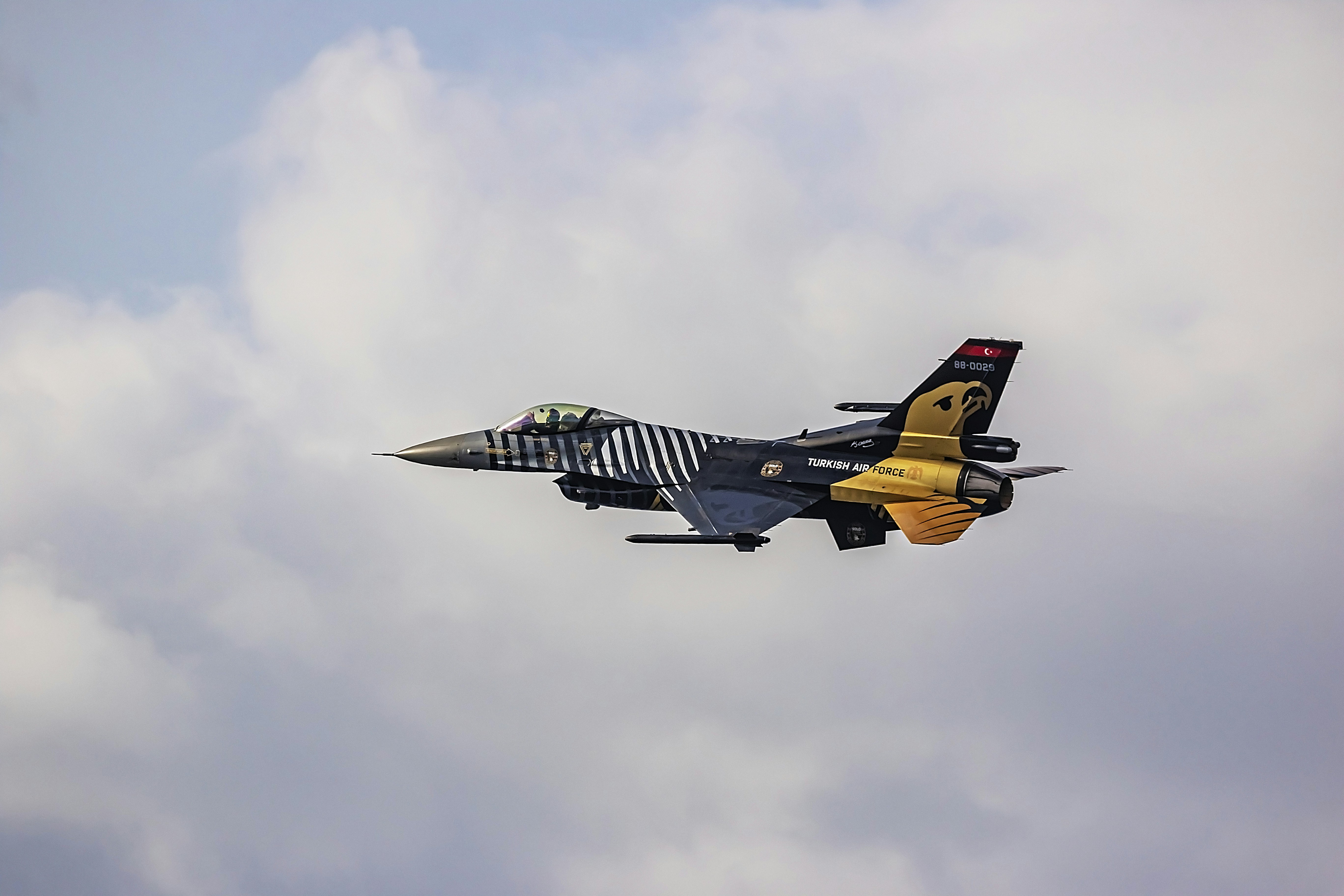 a fighter jet flying through a cloudy sky, Soloturk is performing at the Malta International Airshow.