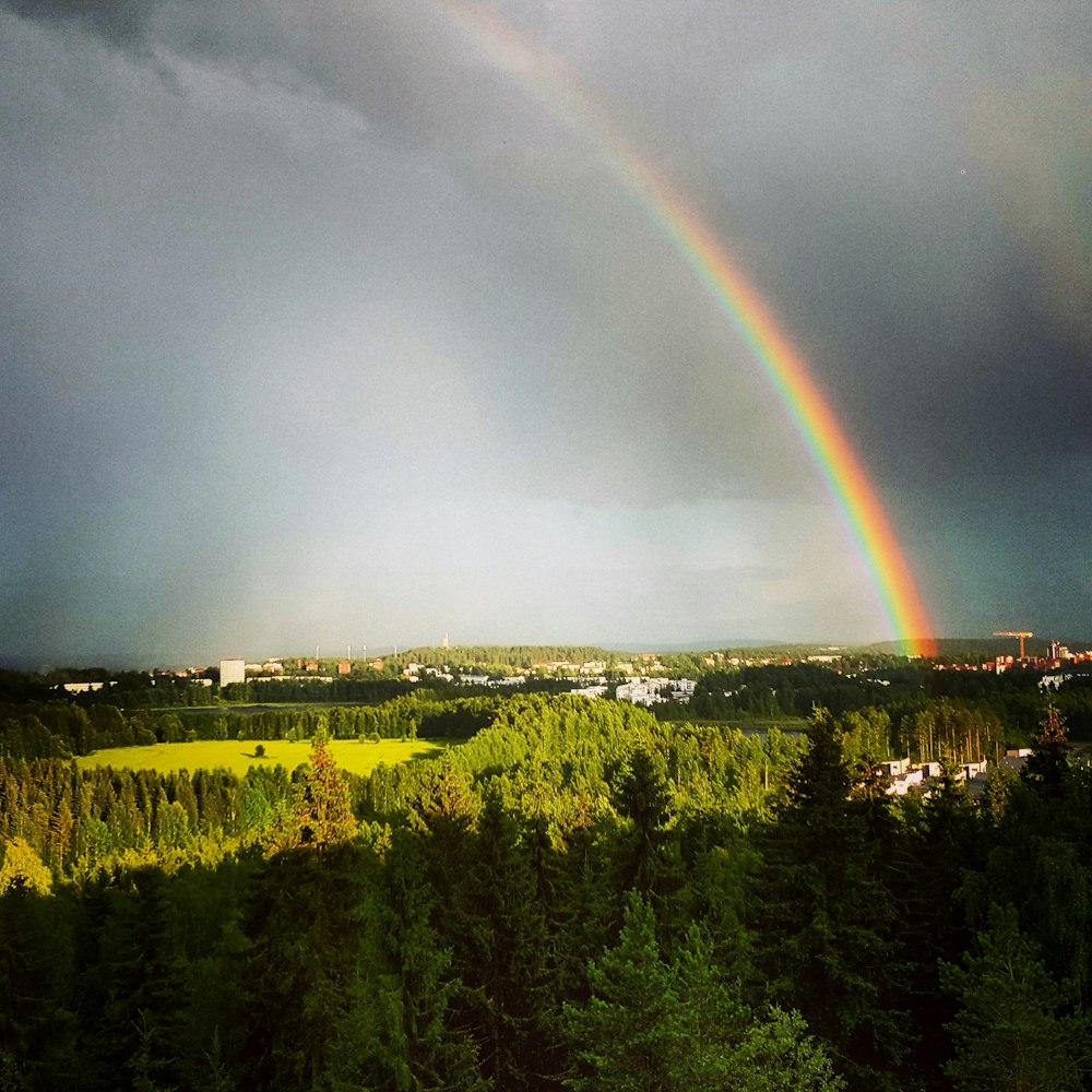 a rainbow appears over a city in the distance