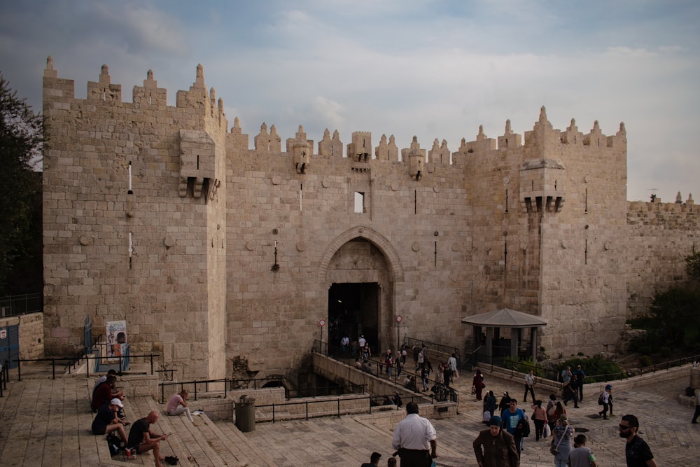 a group of people standing in front of a castle