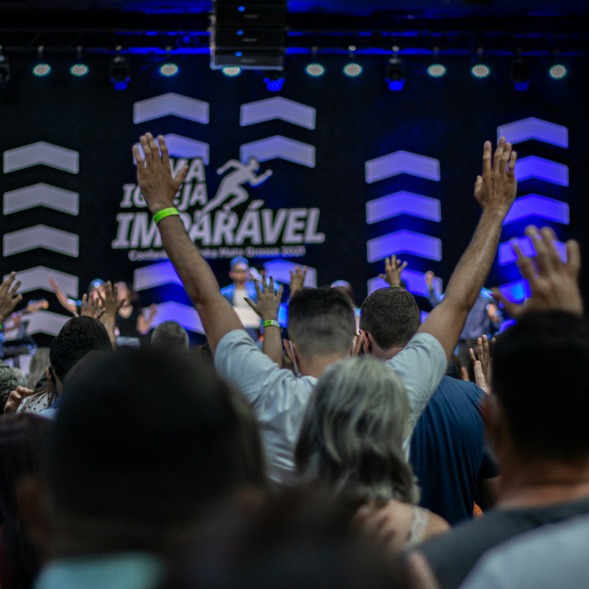 a crowd of people raising their hands in the air