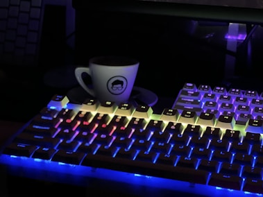 a cup of coffee sitting on top of a keyboard