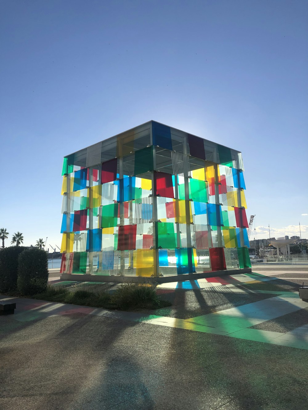 a multicolored building sits in the middle of a parking lot
