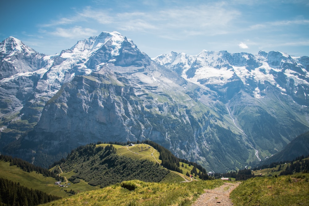 eine Bergkette mit einem Feldweg im Vordergrund