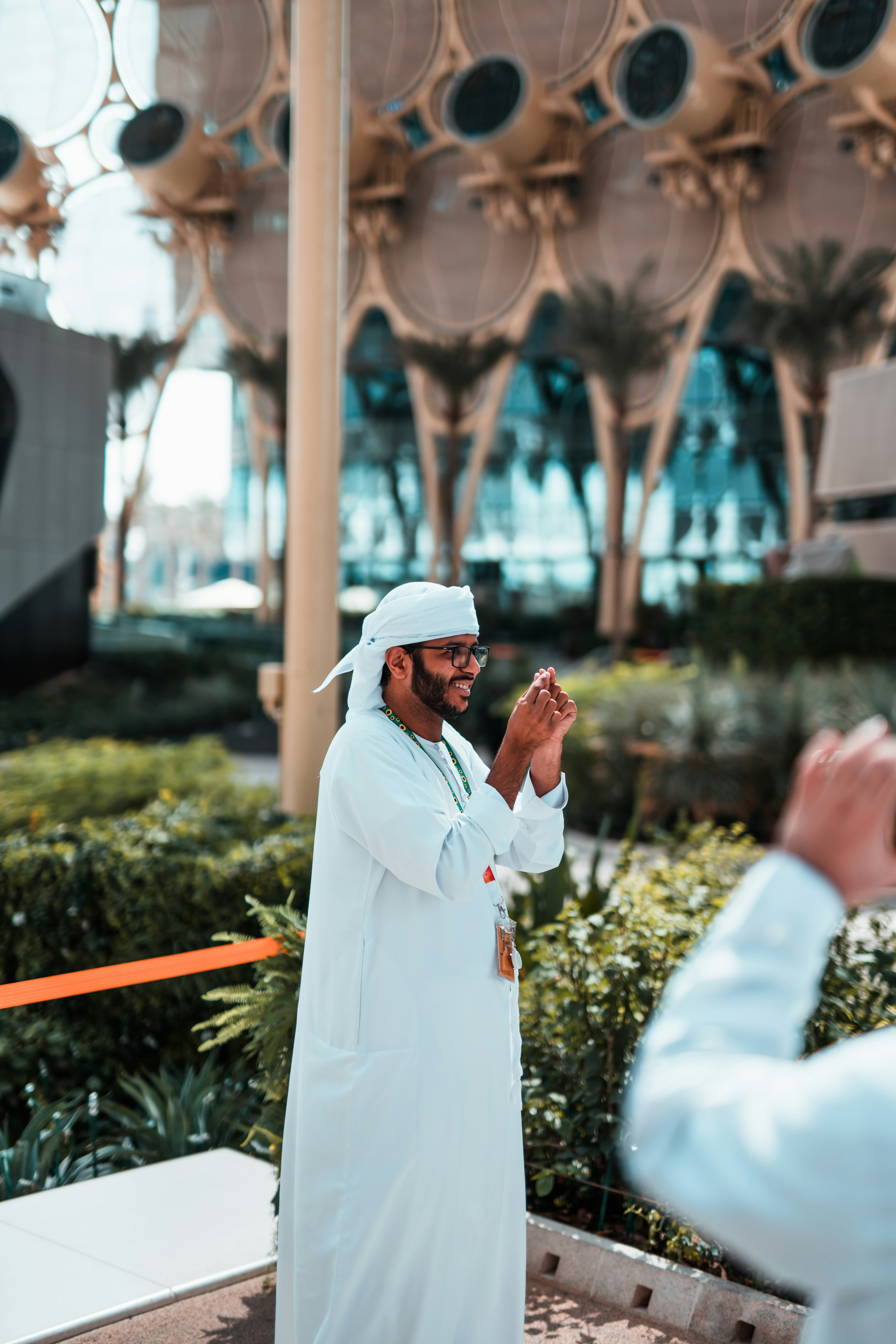 a man in a white outfit standing in front of a building
