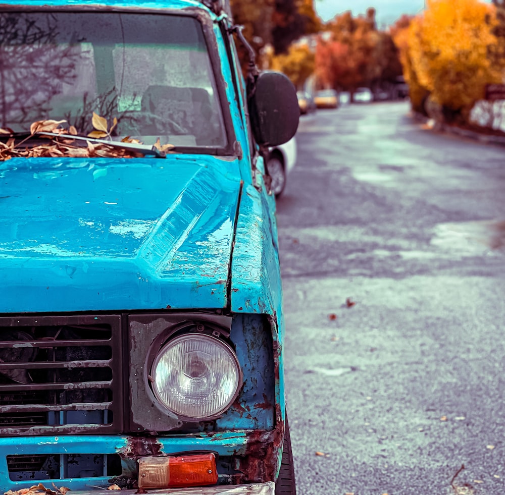 a blue truck parked on the side of a road