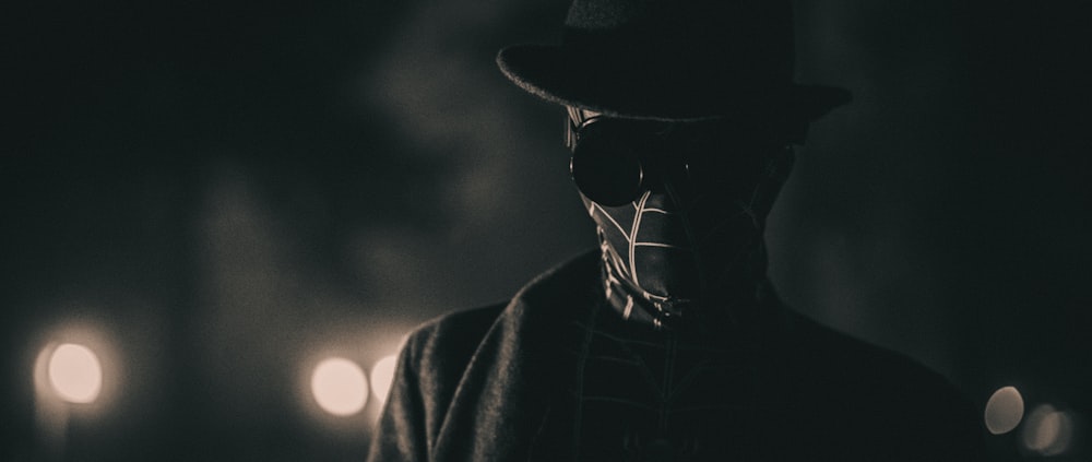 a man in a top hat and coat in a dark room