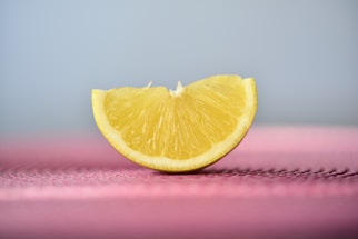 A cheerful lemon slice cartoon waving with a speech bubble saying 'Hello!'