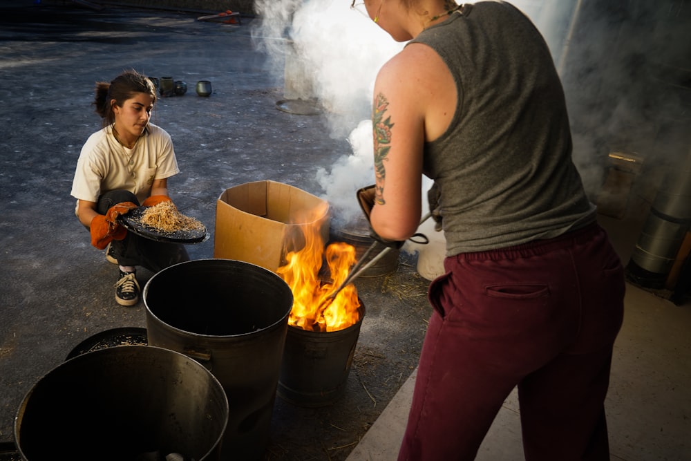a woman cooking food over a fire in a pot