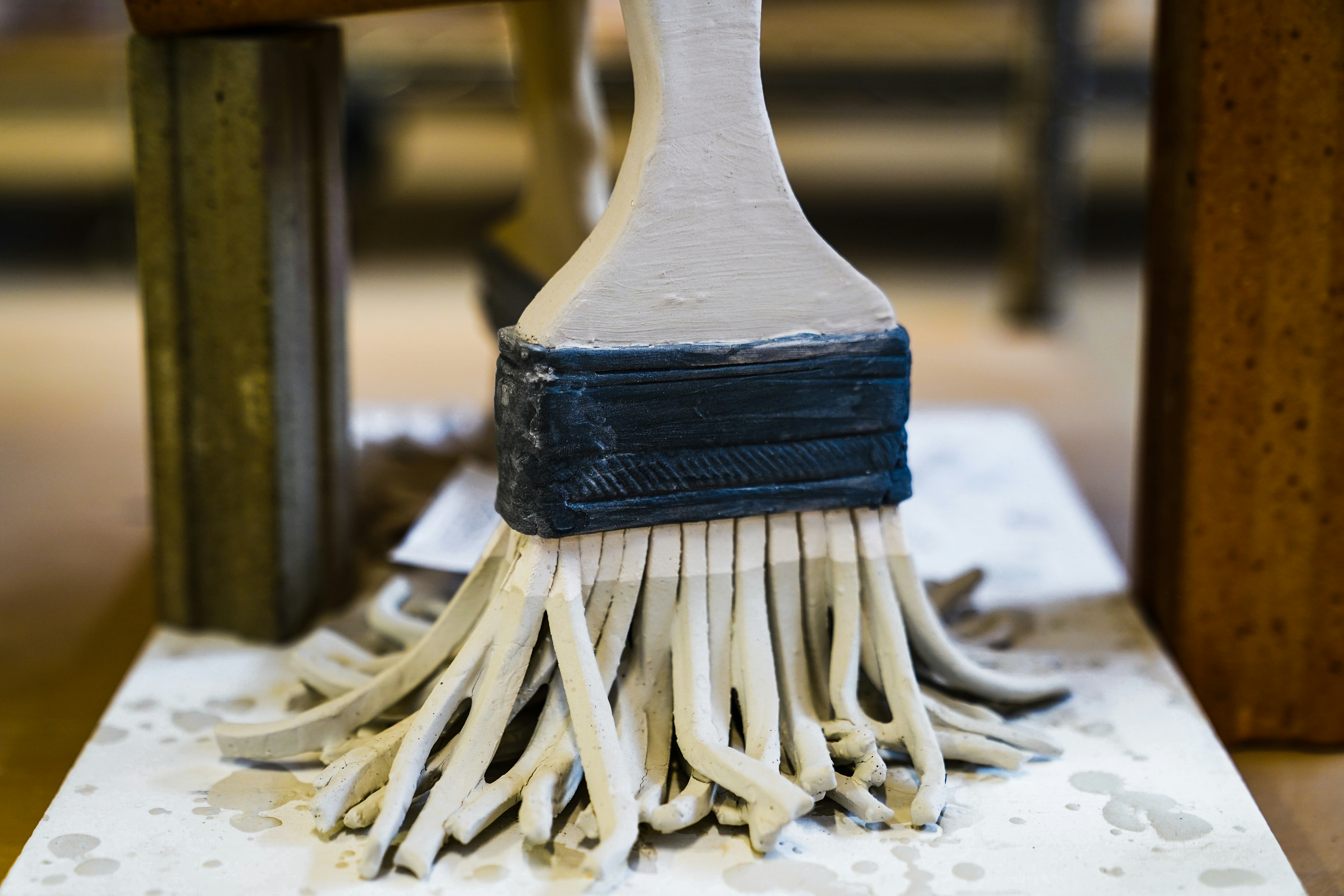 Close-up of a paint brush applying chalk paint to wood furniture — limewash paint vs chalk paint comparison in action