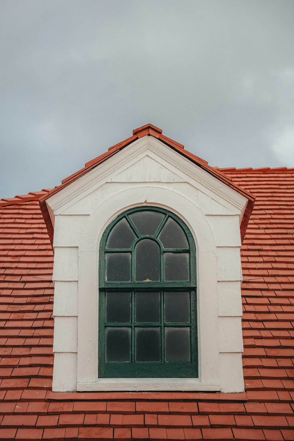 a red roof with a green window and a red tiled roof