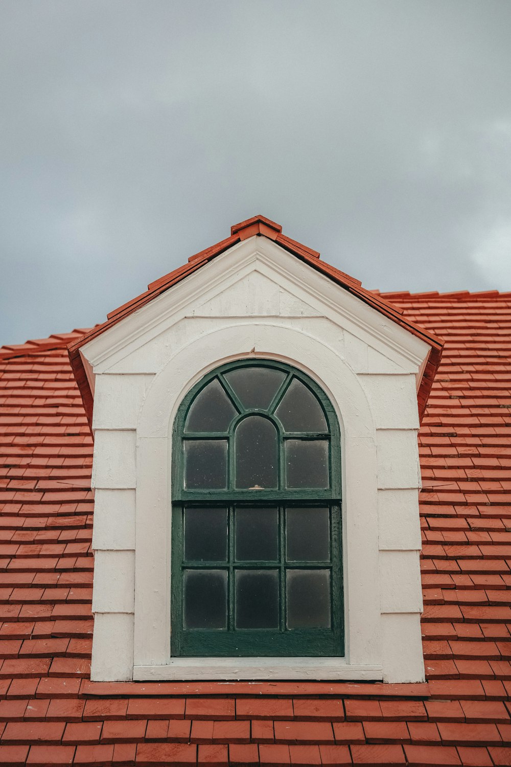 ein rotes Dach mit grünem Fenster und rotem Ziegeldach