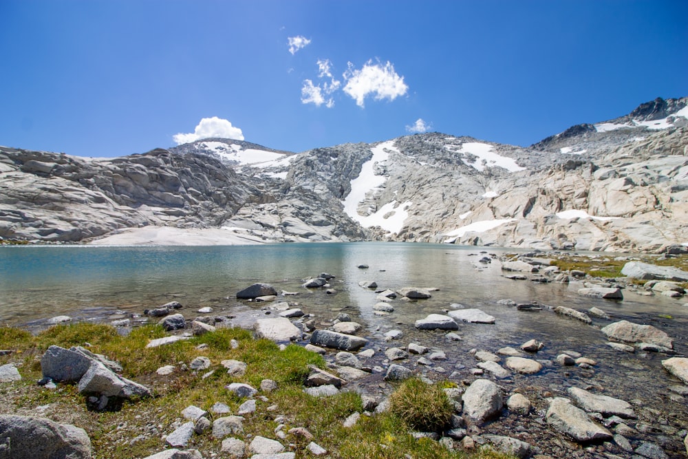 a mountain lake surrounded by rocks and grass