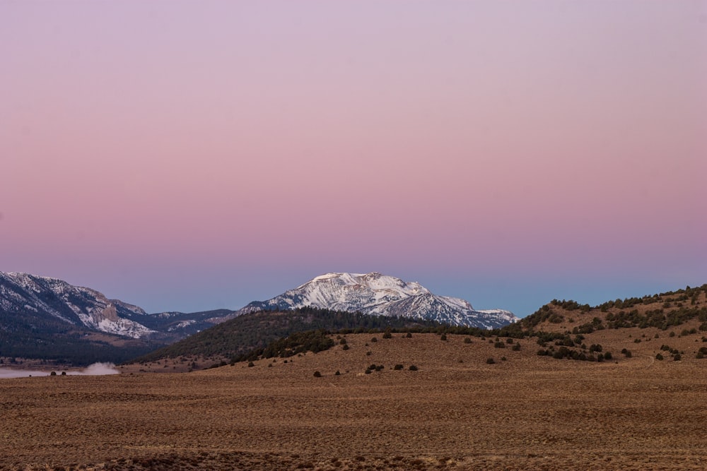 a view of a mountain range with a pink sky