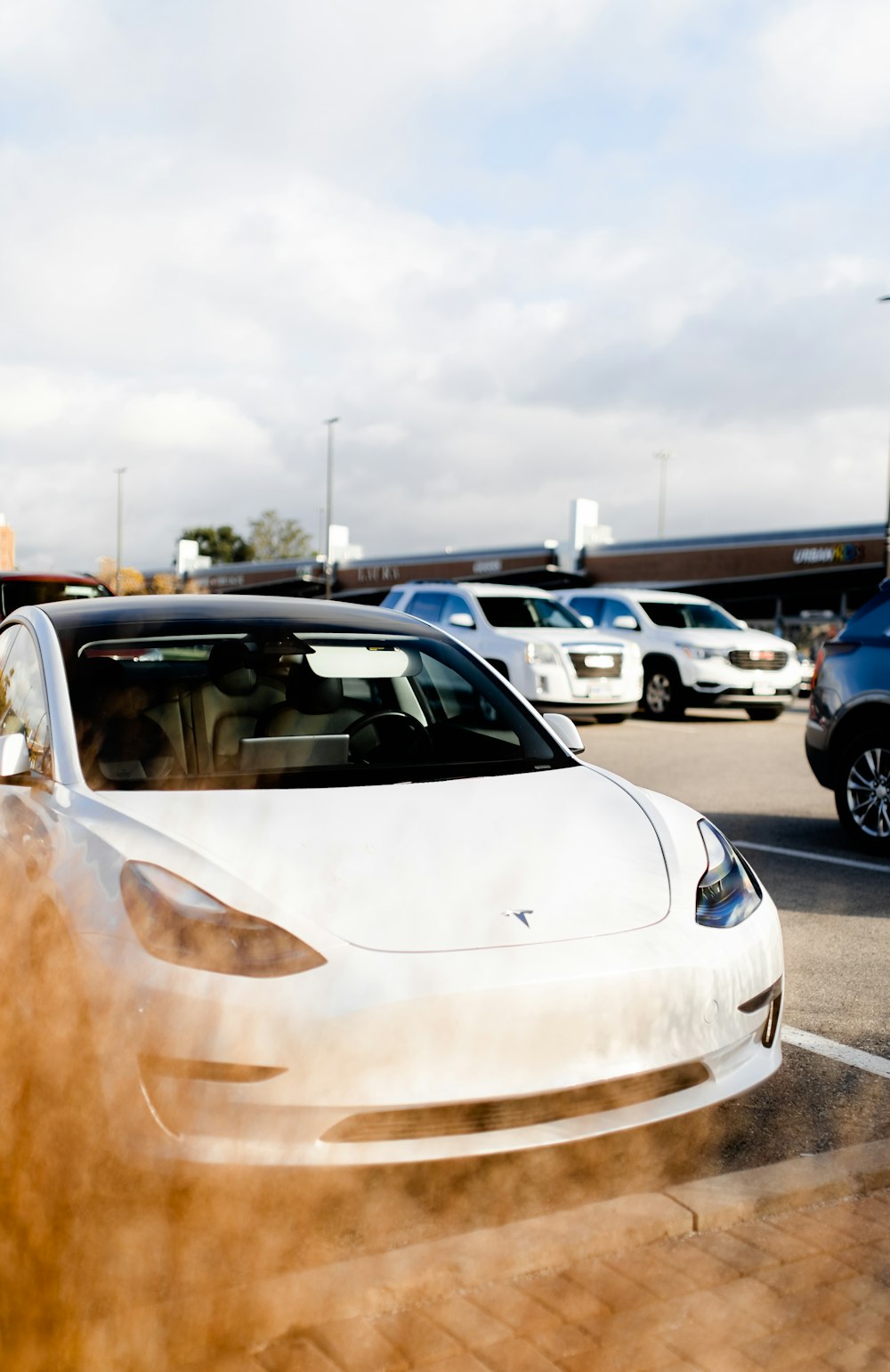 a white tesla parked in a parking lot