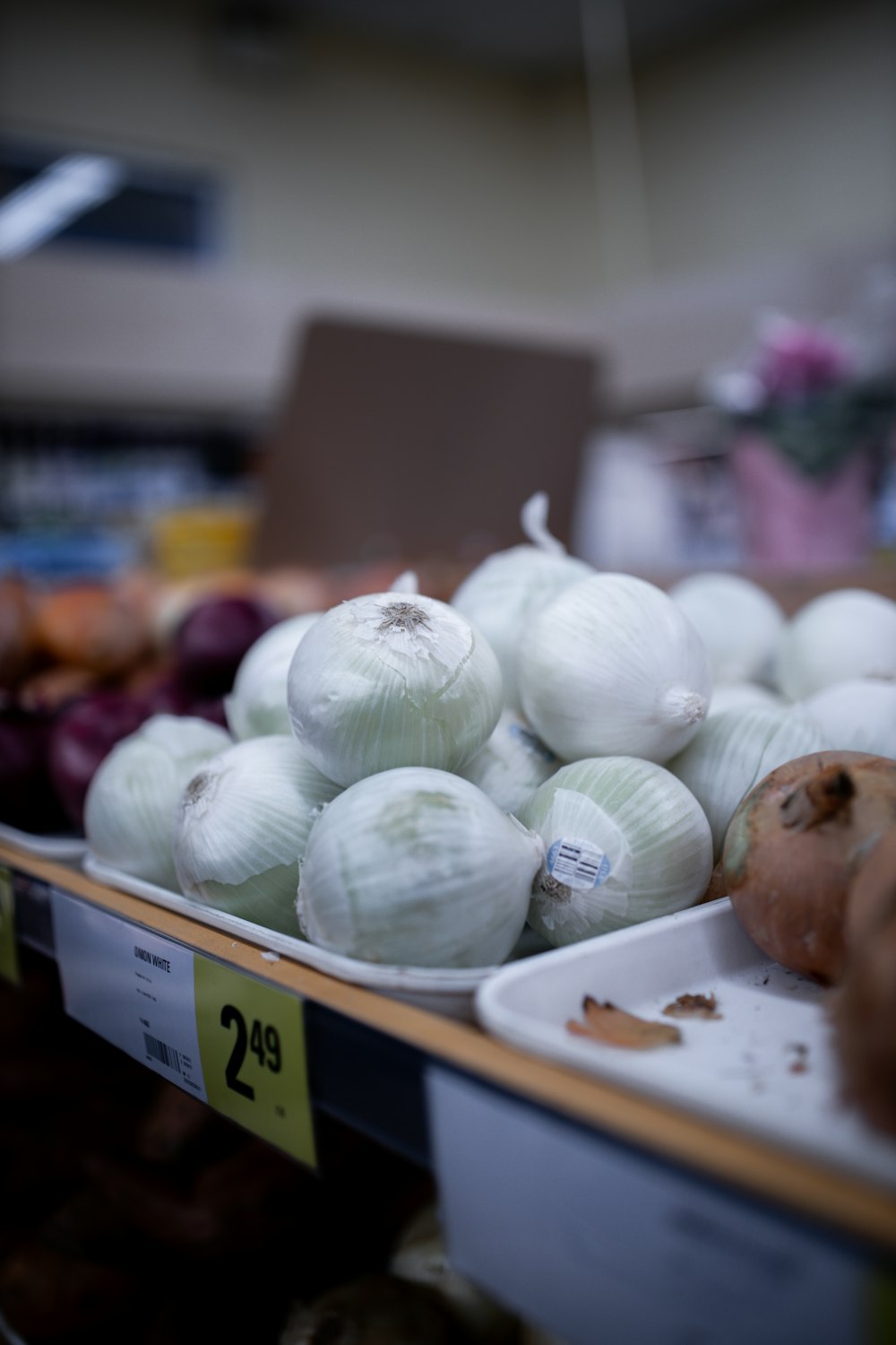 a bunch of onions sitting on a shelf in a store