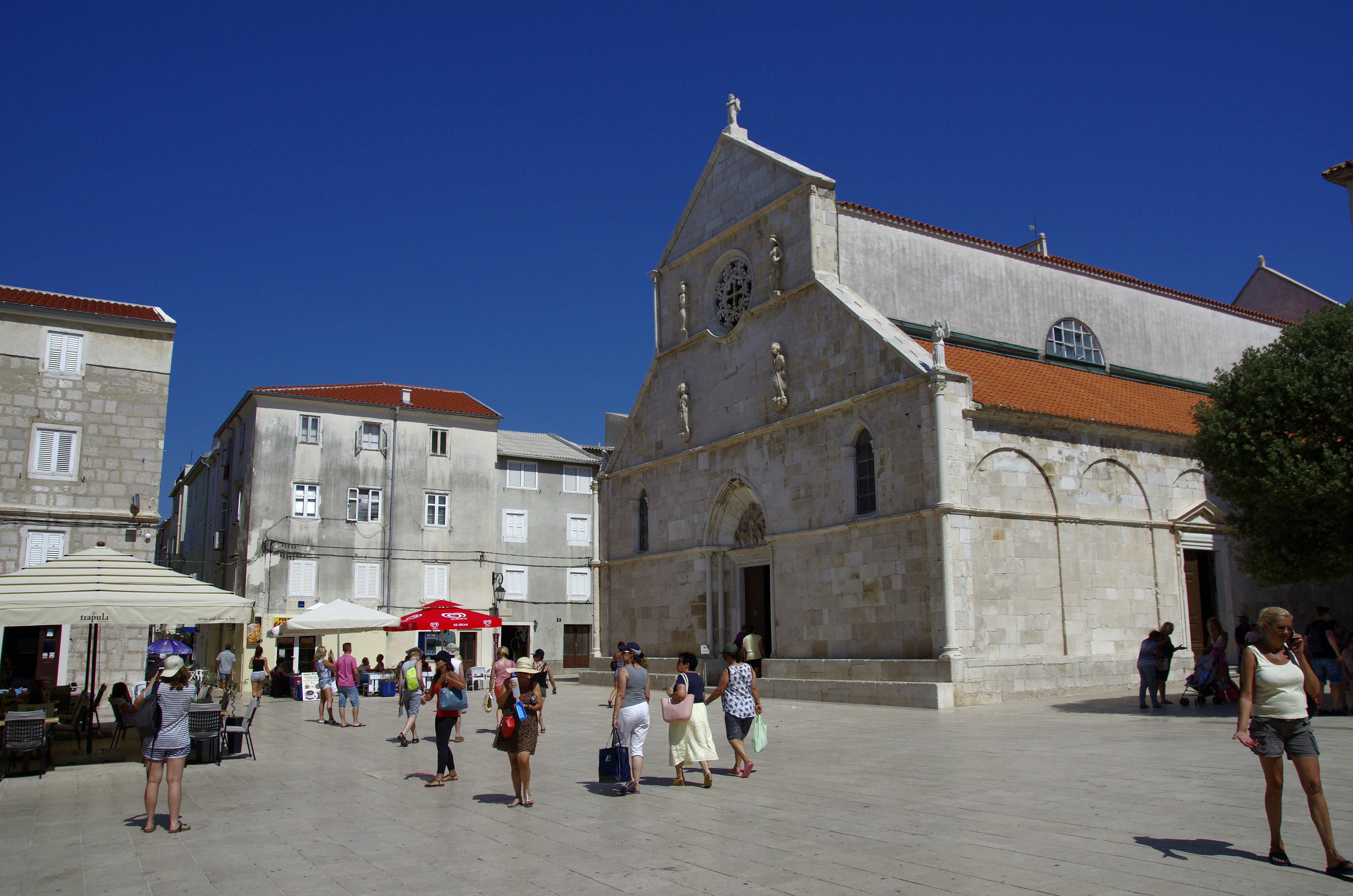 a group of people walking around a city square