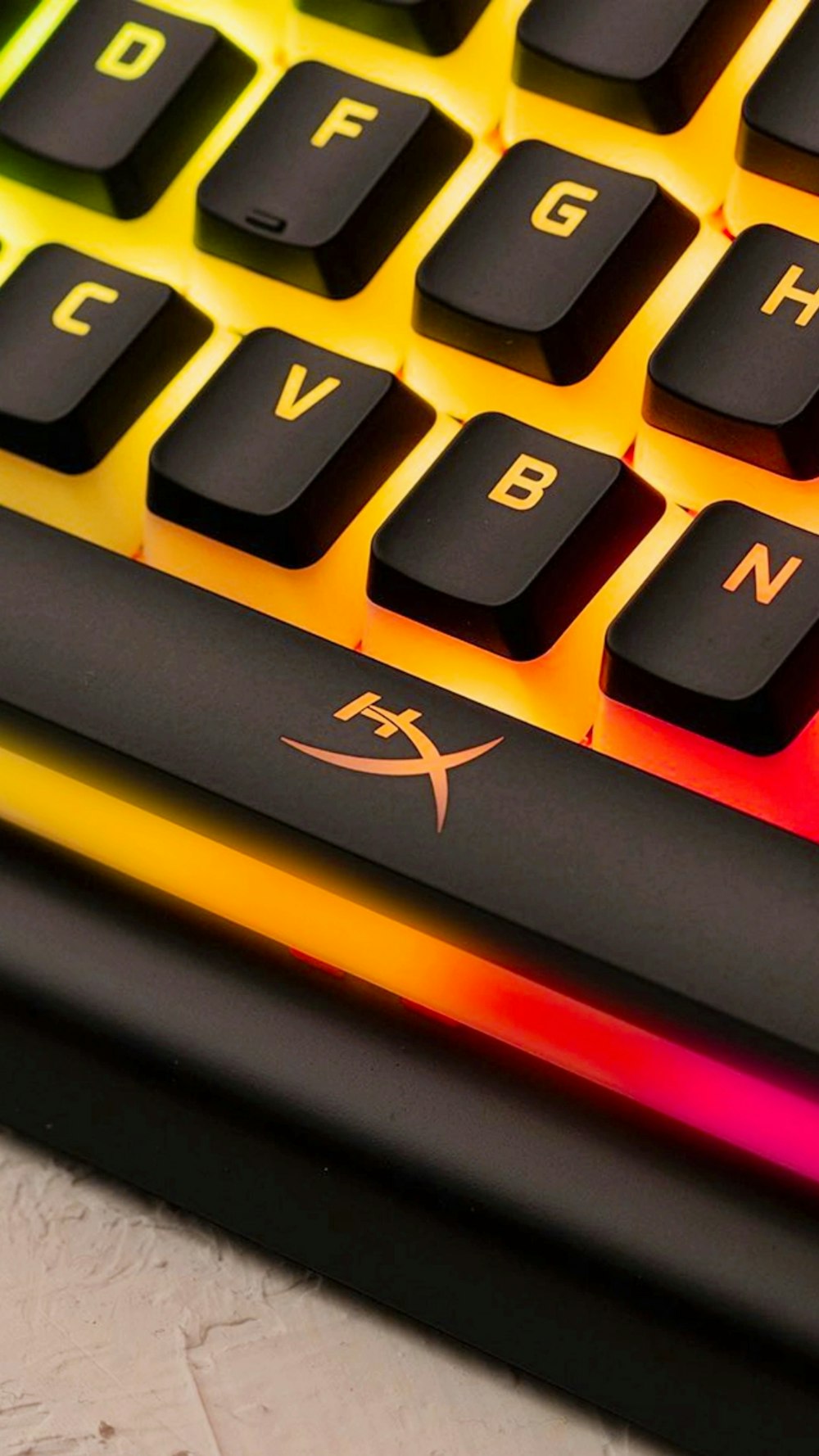 a close up of a computer keyboard with a rainbow light