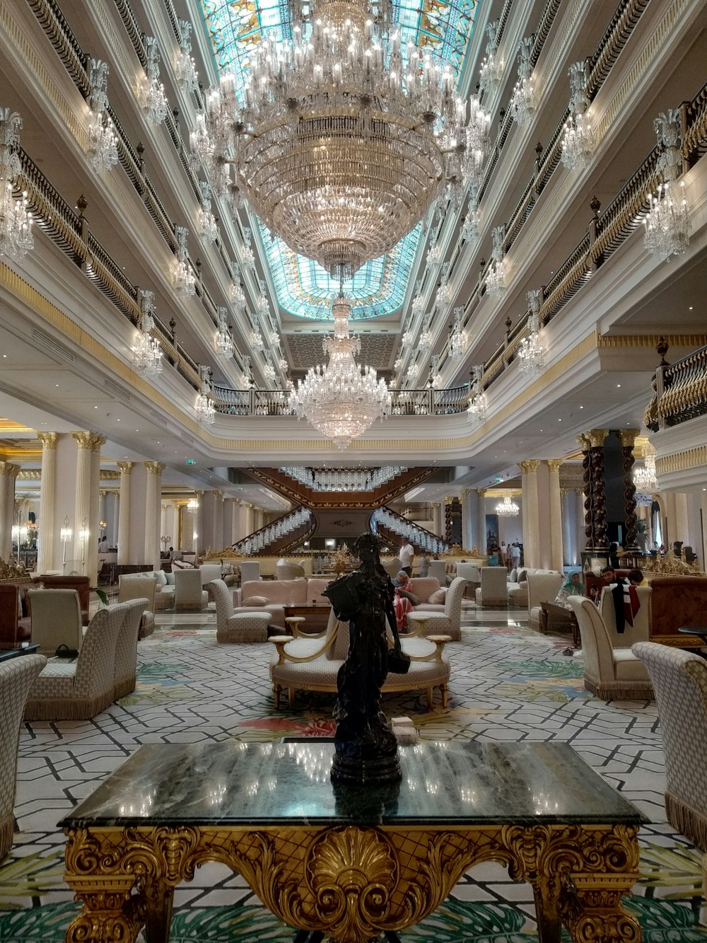 a fancy hotel lobby with chandeliers and seating