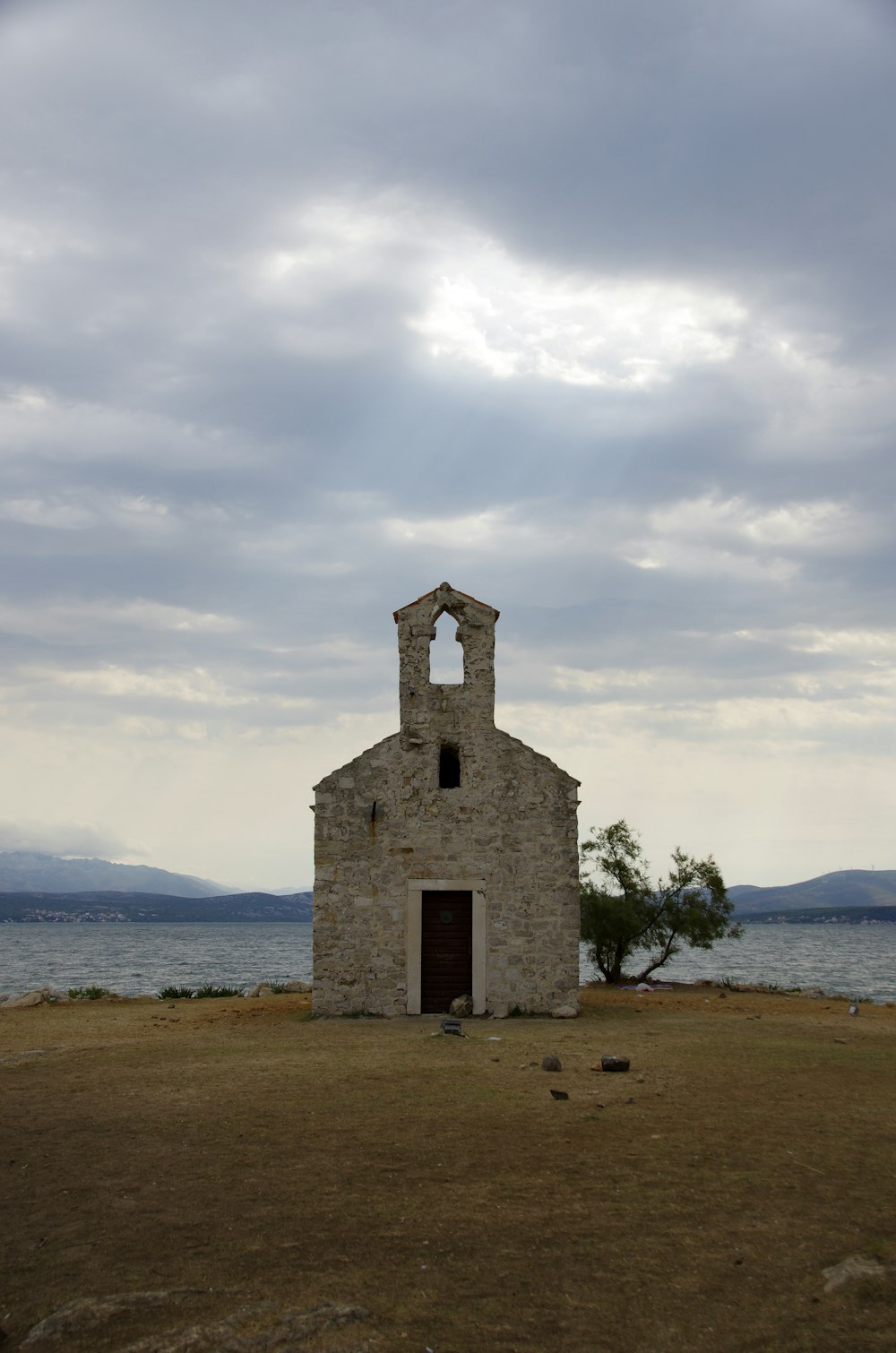 an old church sits on the shore of a lake