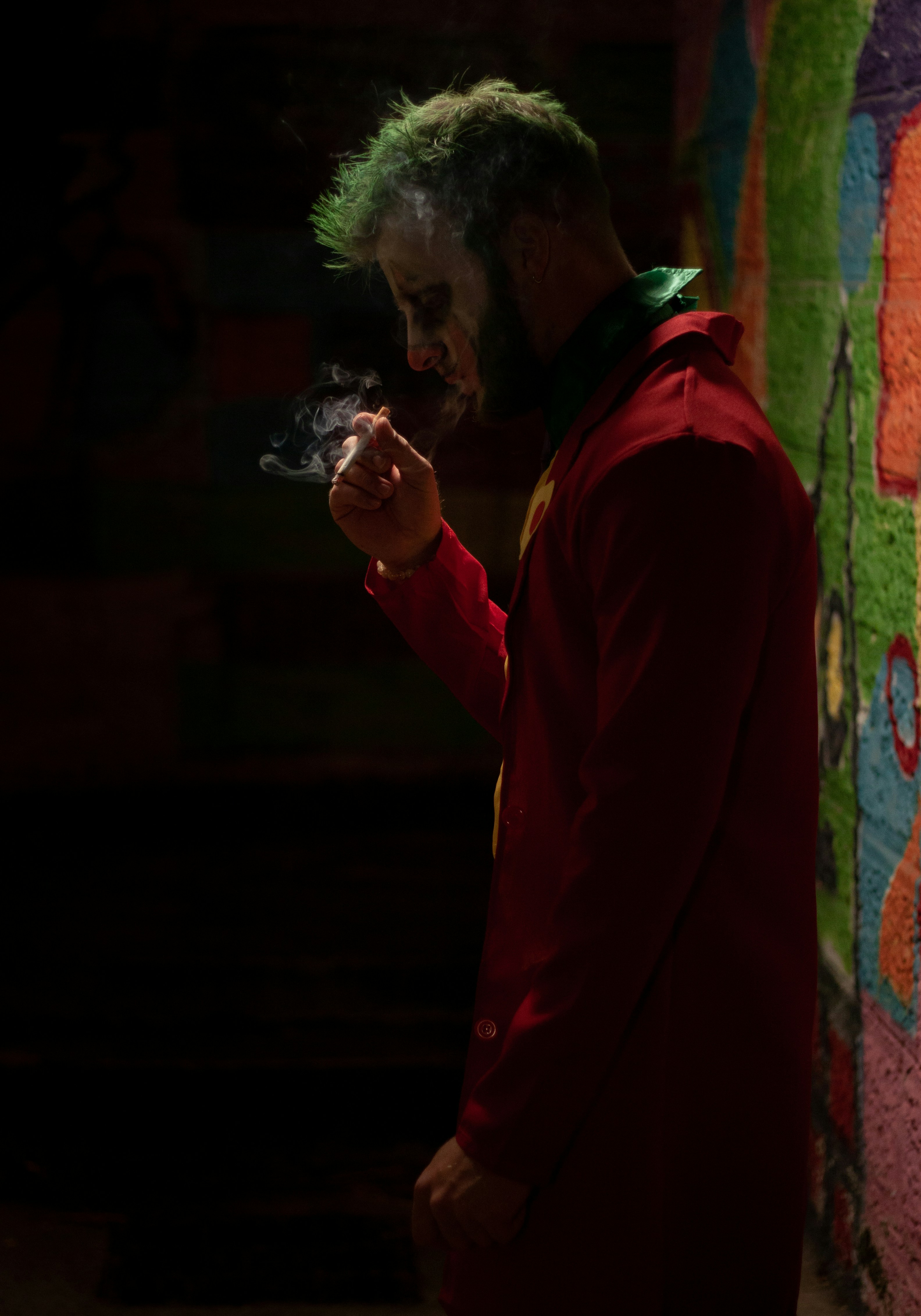 a man in a red jacket smoking a cigarette