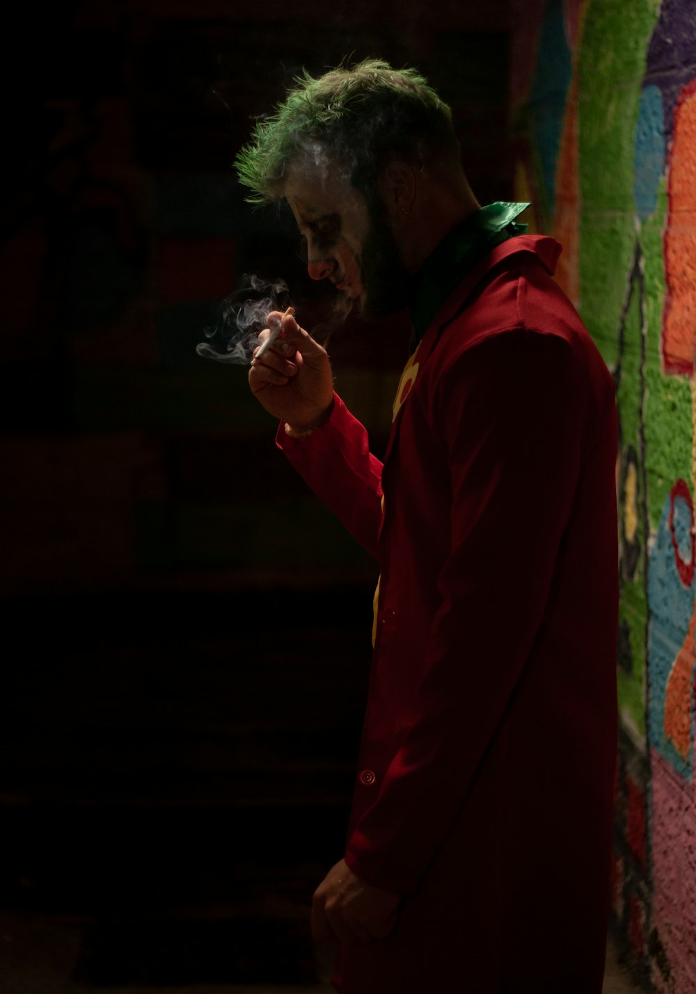 a man in a red jacket smoking a cigarette