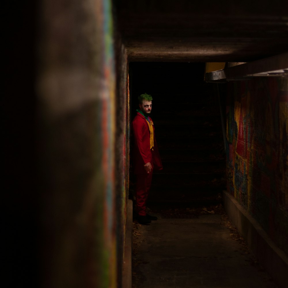 a man in a red suit standing in a tunnel