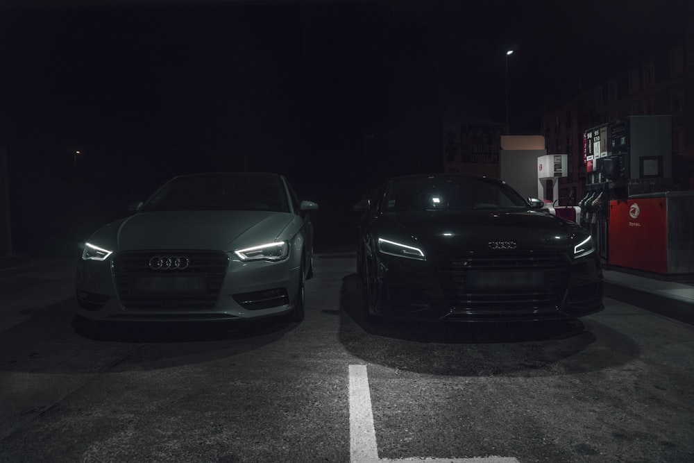 Dos autos estacionados en un estacionamiento por la noche