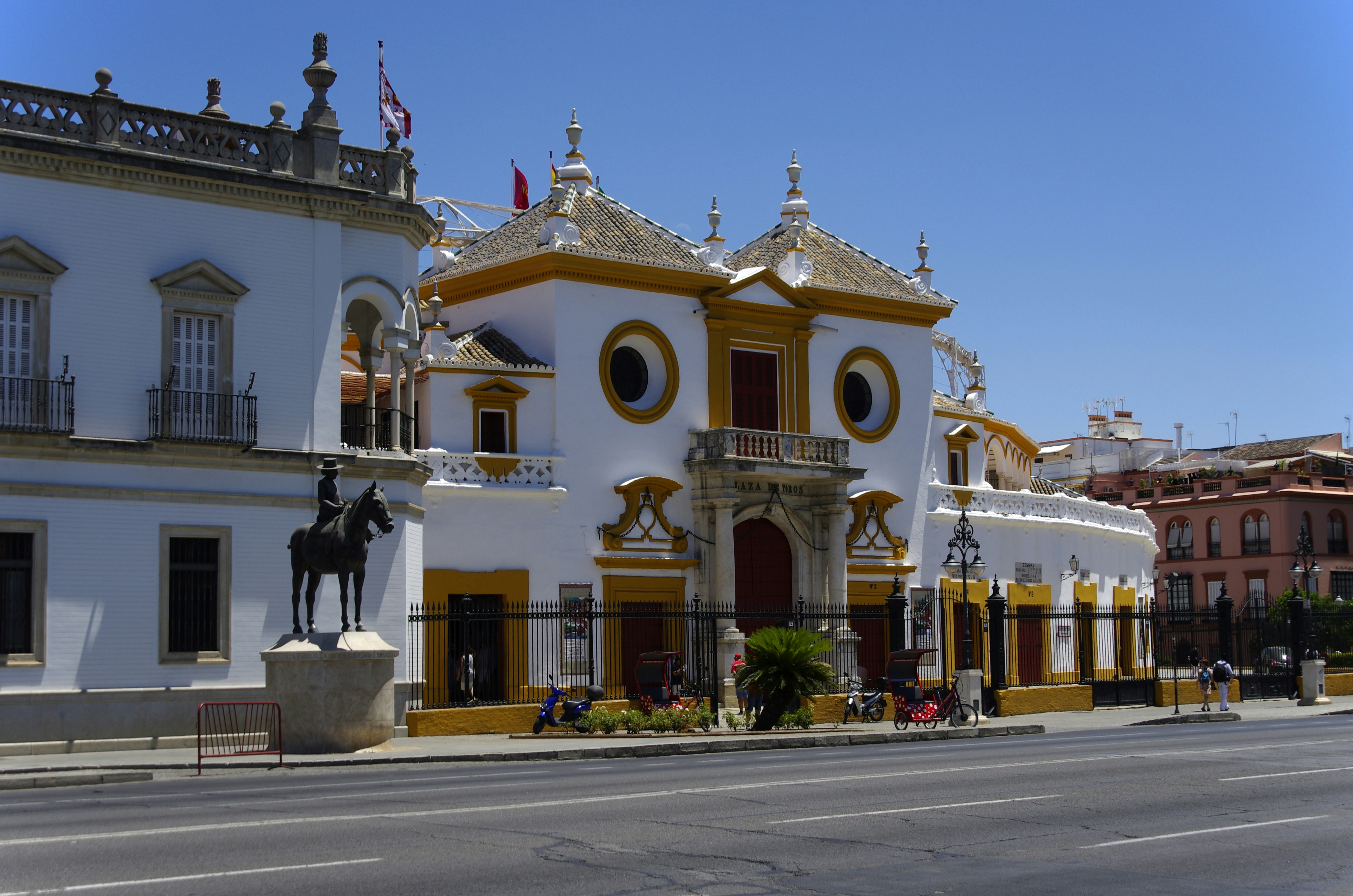a white and yellow building with a horse statue in front of it