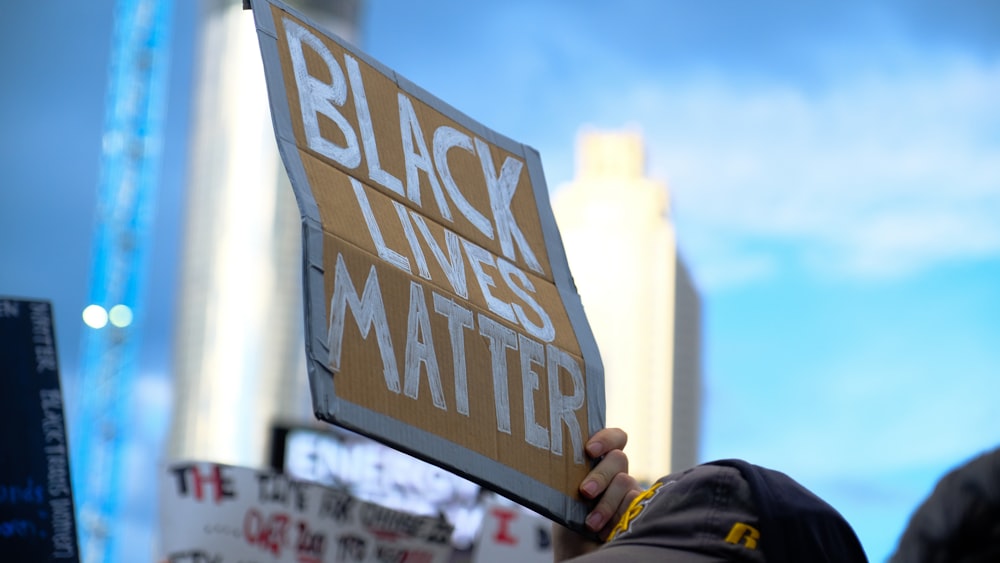 a person holding a black lives matter sign