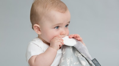 a baby is holding a napkin in his mouth