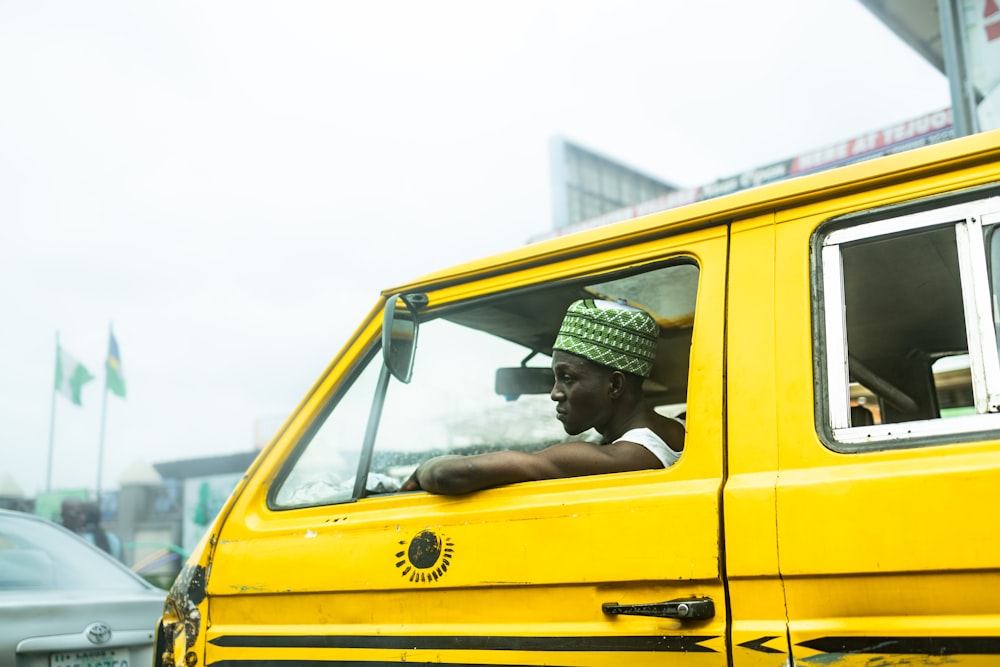 a man driving a yellow van down a street