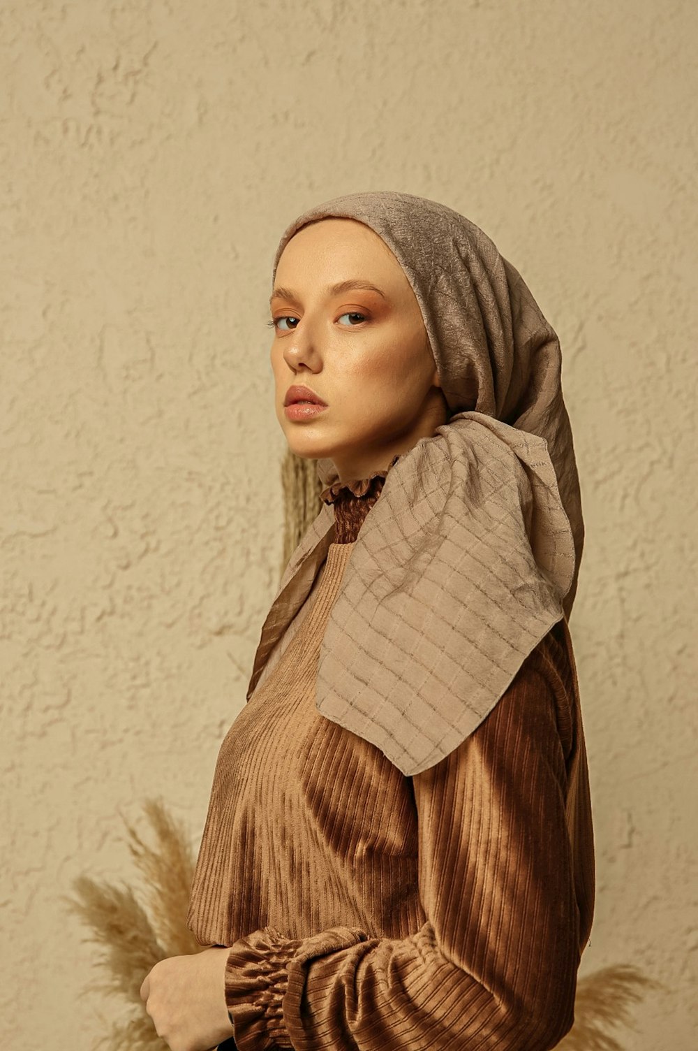 a mannequin wearing a brown dress and head scarf