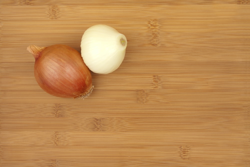 a couple of onions sitting on top of a wooden cutting board